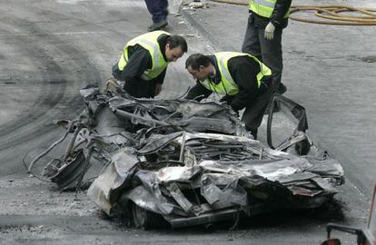 Especialistas de la policía examinan los restos de los coches destrozados por el atentado de ETA en la T4 de Barajas en diciembre de 2006.