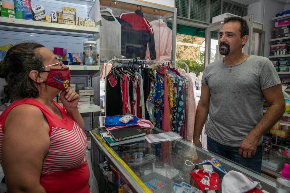 Juan Antonio Collantes, en la mercería de su barrio, con una de las vecinas fan de los textos de ánimo que publica