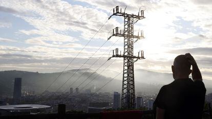 Una persona observa el cableado con el que red eléctrica transporta la energía sobre la ciudad de Bilbao.