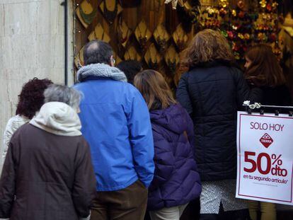 Clientes a la puerta de un comercio en Madrid.