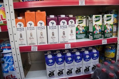 Un estante de un supermercado con cartones de leche y productos lácteos.