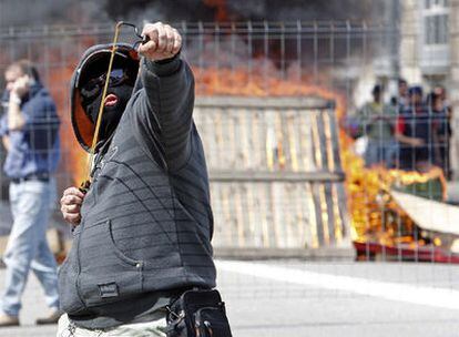 Uno de los huelguistas lanza objetos contra los antidisturbios en las proximidades del astillero de Hijos de J. Barreras.