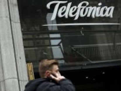 Un hombre camina junto a la sede de Telefónica en Gran Vía.