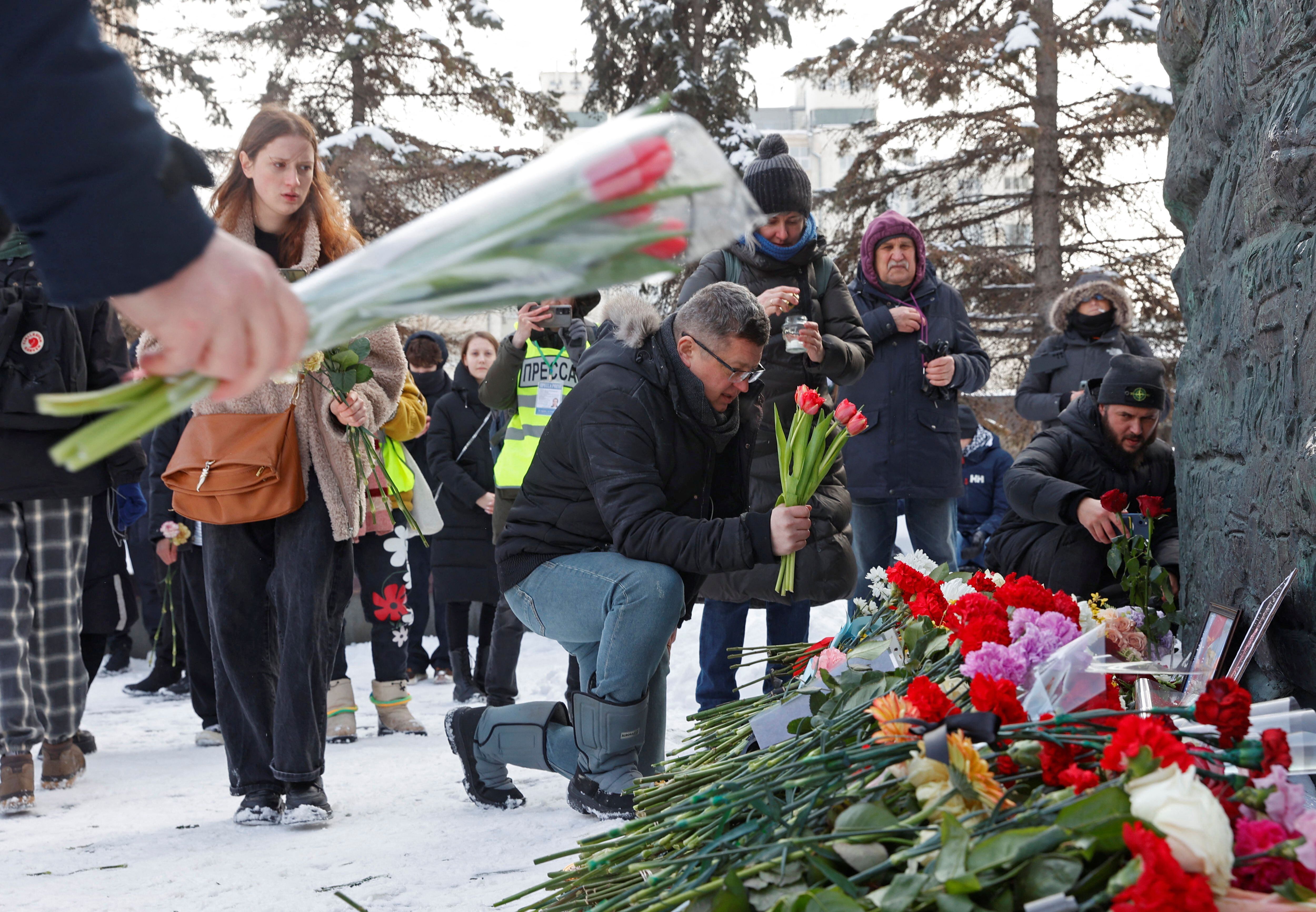 Varias personas dejan flores frente al monumento a las víctimas de la represión política de Moscú, este sábado.