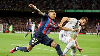 Raphinha trata de progresar con el balón mientras Nacho le agarra durante el Barcelona-Real Madrid (2-1) de este domingo.