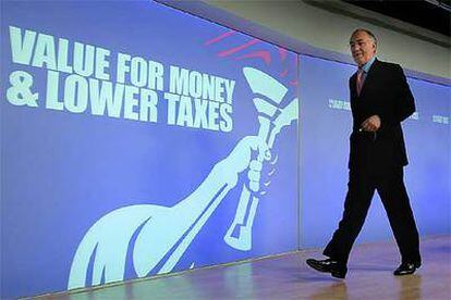 El líder conservador, Michael Howard, ante un eslogan que dice: "Dar valor al dinero y bajar los impuestos".