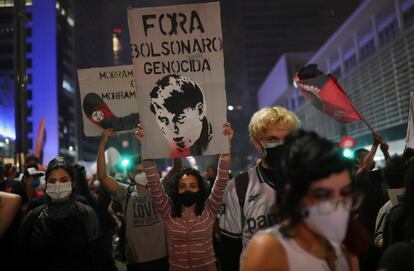 Un manifestante marcha con un cartel que dice "Fuera del genocidio de Bolsonaro" este sábado en la Avenida Paulista de Sao Paulo.