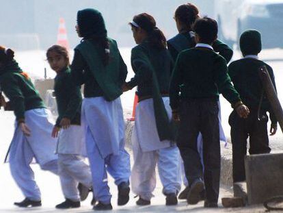 Un grupo de escolares de la escuela atacada en Peshawar (Pakist&aacute;n) se aleja del lugar del atentado.