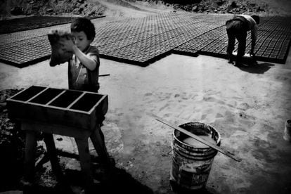 Niño trabajando junto a su padre en una ladrillera de Huachipa (Lima). Mientras el menor coloca el barro en la gabera para dar la forma de ladrillo, su padre los coloca al sol.