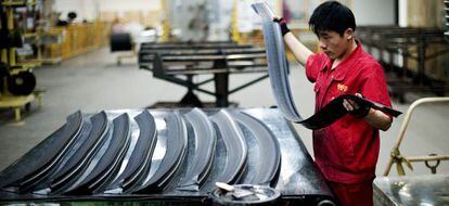 Un trabajador manipula caucho en una f&aacute;brica de Pirelli en China.