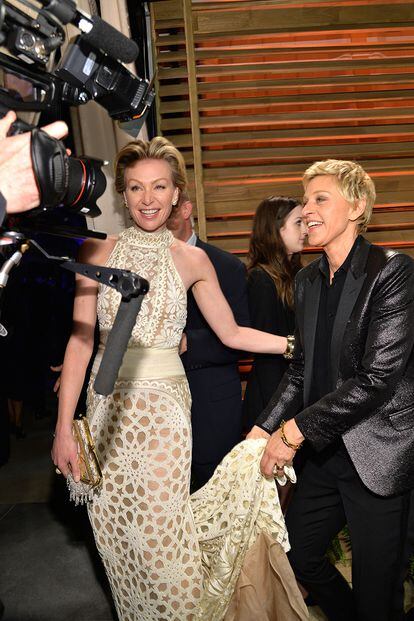 La presentadora de la gala Ellen DeGeneres, ya relajada, y su mujer Portia de Rossi bromean en la entrada a la fiesta Vanity Fair.