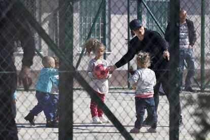 Una agente de policía juega con niños repatriados con sus madres desde Siria, el sábado en un centro de detención de Kosovo.