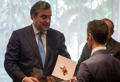 El embajador de España en Venezuela recibe un obsequio de sus compañeros durante una reunión.