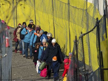 Refugiados caminan a lo largo de una valla instalada en la frontera con Eslovenia, en Spielfeld, Austria.
