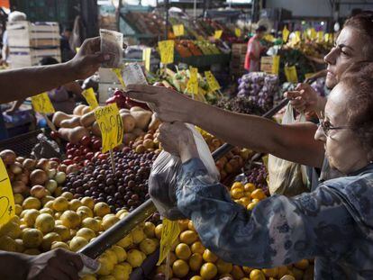 Dos mujeres pagan una bolsa de frutas en el Mercado Central de Buenos Aires