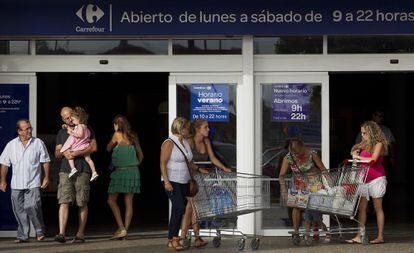 Varias personas en la zona de acceso de un hipermercado Carrefour de M&aacute;laga. 