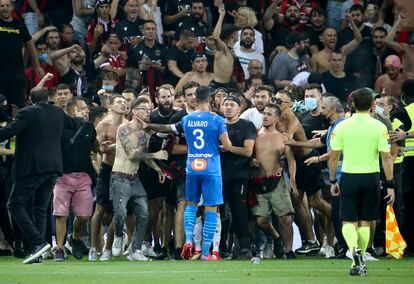 Álvaro, jugador del Marsella, se enfrenta a ultras del Niza que invadieron la cancha durante el partido de liga entre los dos equipos que fue suspendido ayer.