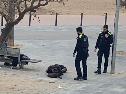 Dos agentes, ante el hombre agredido en la Barceloneta.