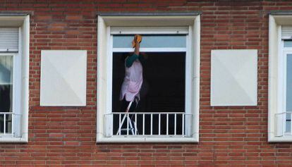 Una empleada del hogar limpia la ventana de un piso. / ÁLVARO GARCÍA