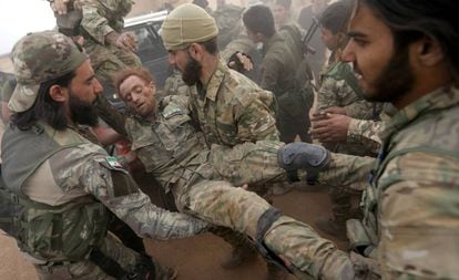 Combatientes de las facciones rebeldes sirias favorables a Turquía atienden a un herido.