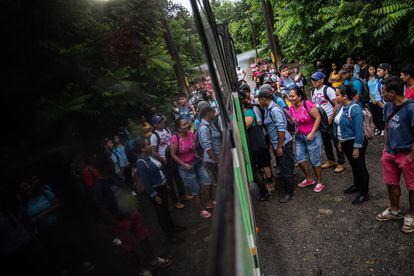 Mujeres y hombres, en su mayoría migrantes nicaragüenses, hacen cola para coger los pocos autobuses que pasan desde Las Brisas, un barrio de migrantes, que les llevarán a sus trabajos en la construcción y los servicios de limpieza.