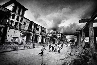 Un grupo de niños juega en las calles de Mogadiscio entre edificios arrasados por la guerra.