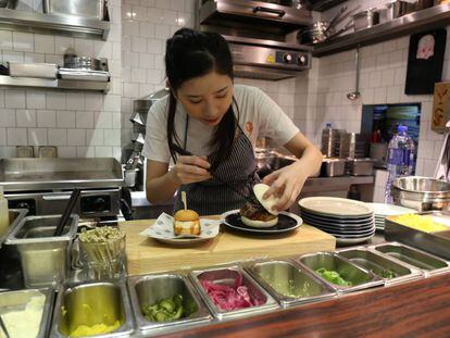 Personal del restaurante Little Bao preparando dos de las especialidades.