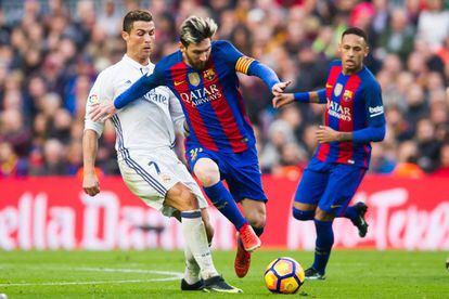 Lionel Messi del FC Barcelona controla el balón presionado por Ronaldo del Real Madrid.