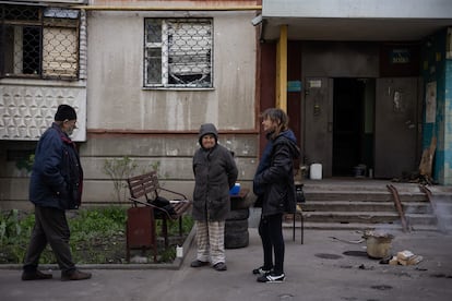 Residents of the Saltivka neighborhood cook outside their house.