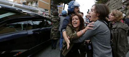 Una manifestante grita al paso del coche f&uacute;nebre con los restos de Erich Priebke.