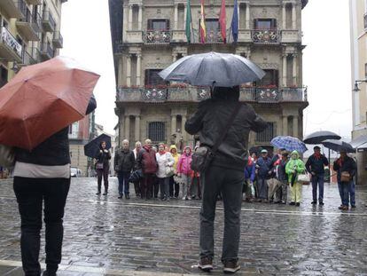 Un grupo de turistas se fotografía frente al Ayuntamiento de Pamplona.