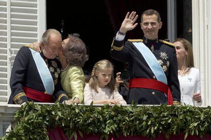 La reina Sofía besa al rey Juan Carlos en el balcón del Palacio Real de Madrid, mientras Felipe VI saluda al público congregado en la plaza de Oriente, junto a la princesa Leonor y la reina Letizia, en la proclamación del nuevo monarca, el 19 de junio de 2014.