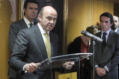 Luis de Guindos (izquierda) y José María Aznar en la toma de posesión de altos cargos. Detrás, el ministro de Industria, José Manuel Soria.