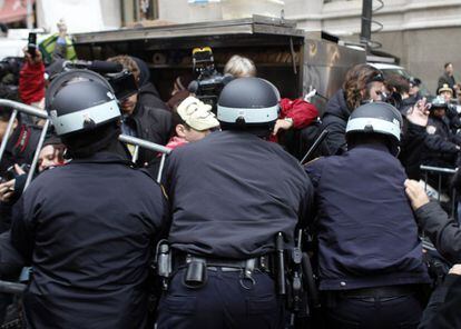 Policías tratan de impedir el avance de los manifestantes por las calles del barrio financiero de Nueva York.