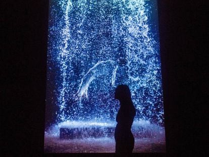 Una visitante contempla una obra de Viola en la exposición. A la izquierda, el Taddei Tondo, de Miguel Ángel. En vídeo, Bill Viola y Miguel Ángel 'conversan' sobre la vida con sus obras en Londres.