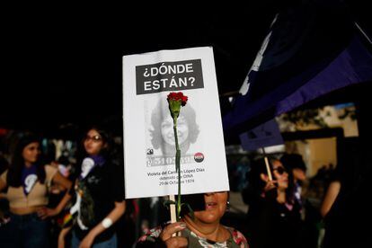 Una mujer con un cartel de búsqueda de una persona desaparecida en la marcha por el Día Internacional de la Mujer, este miércoles en Santiago (Chile).