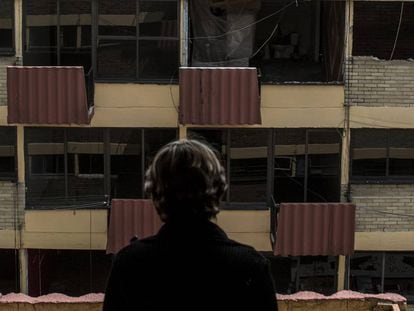 Una mujer mira un edificio de la Unidad Tlalpan, afectada por el sismo.