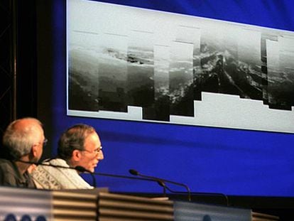 Dos científicos de la Agencia Europea del Espacio observan una panorámica de la superfice de Titán.