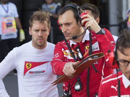 Sebastian Vettel escucha a un miembro del equipo Ferrari en el circuito de Bak&uacute;.
