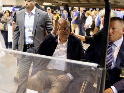 Warren Buffett saluda a los asistentes mientras circula en un carrito de golf en la junta de accionistas de Berkshire Hathaway.