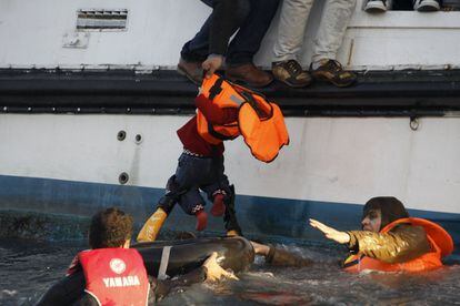 Un voluntario socorre a un bebé tras ser rescatado de la embarcación naufragada en las costas de la isla griega de Lesbos.