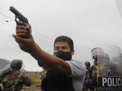 Un miembro de la Policía peruana apunta su arma a manifestantes, el miércoles durante una protesta de trabajadores agroindustriales.