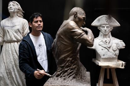 Jose Carlos Vargas junto a la escultura del futbolista Paolo Guerrero, en su taller de Lima, el 20 de septiembre.