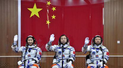 De izquierda a derecha, los astroinautas Liu Yang, Jing Haipeng y Liu Wang, posan tras un cristal protector en el centro de lanzamiento de Jiuquan.