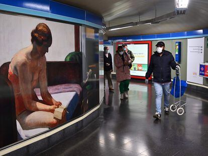 Usuarios del Metro de Madrid, en el pasillo de una estación el pasado lunes.