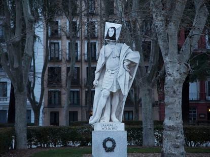 Una de las estatuas de la madrileña plaza de Oriente tapadas con efigies femeninas con ocasión del Día de la Mujer, este lunes. CARANTONIA
