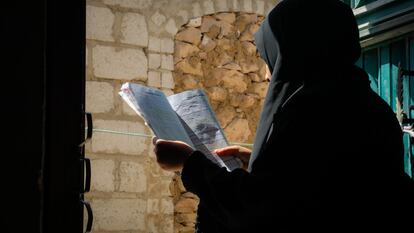 Asma'a, una niña de 15 años que se libró del matrimonio infantil, lee un libro desde el patio de su casa en Dhamar, Yemen.