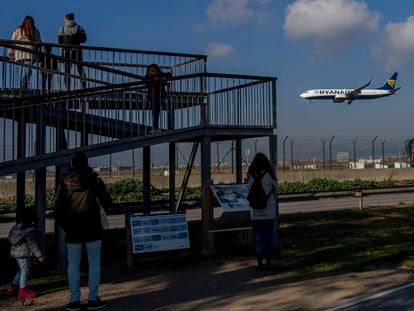 Unos paseantes contemplan el aterrizaje de aviones desde un mirador junto a la Ricarda.