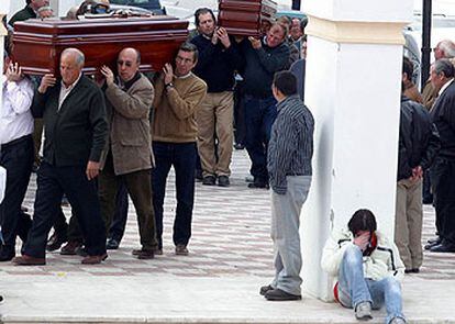 Familiares y amigos de los fallecidos trasladan sus ataúdes a la capilla ardiente.