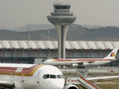 Vista de un avi&oacute;n de Iberia y la torre de control del aeropuerto Madrid-Barajas Adolfo Su&aacute;rez.